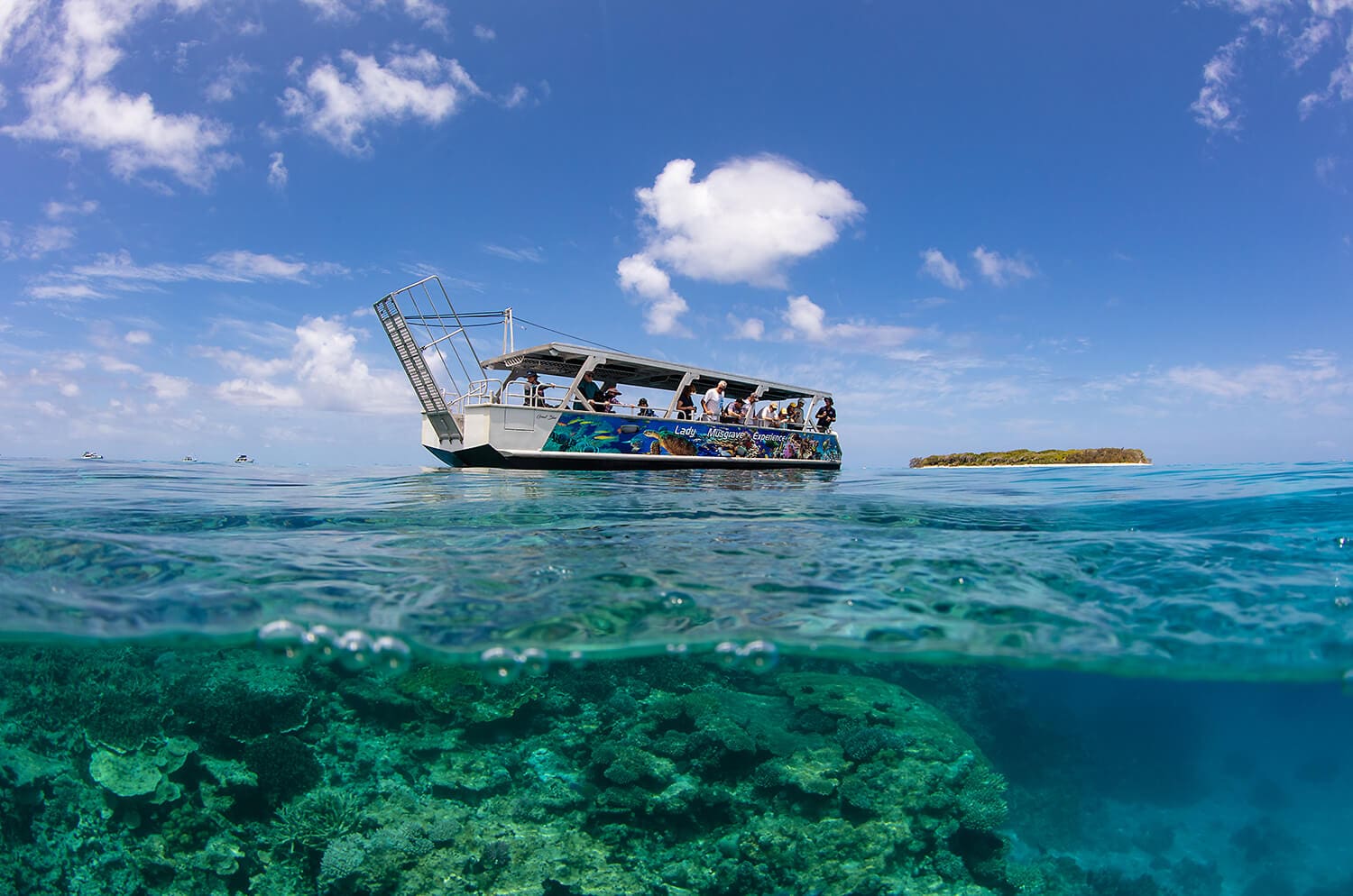 Glass bottom boat above the reef beside the coral cay